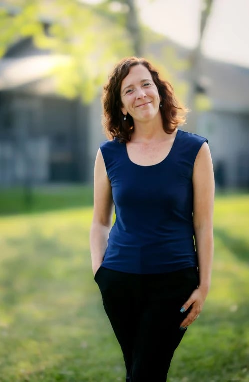 Margaret Simmons standing in a sunlit outdoor garden setting